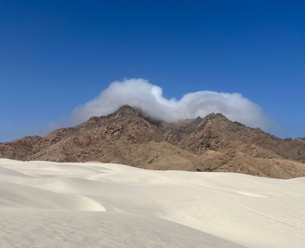 Białe wydmy z górą w tle