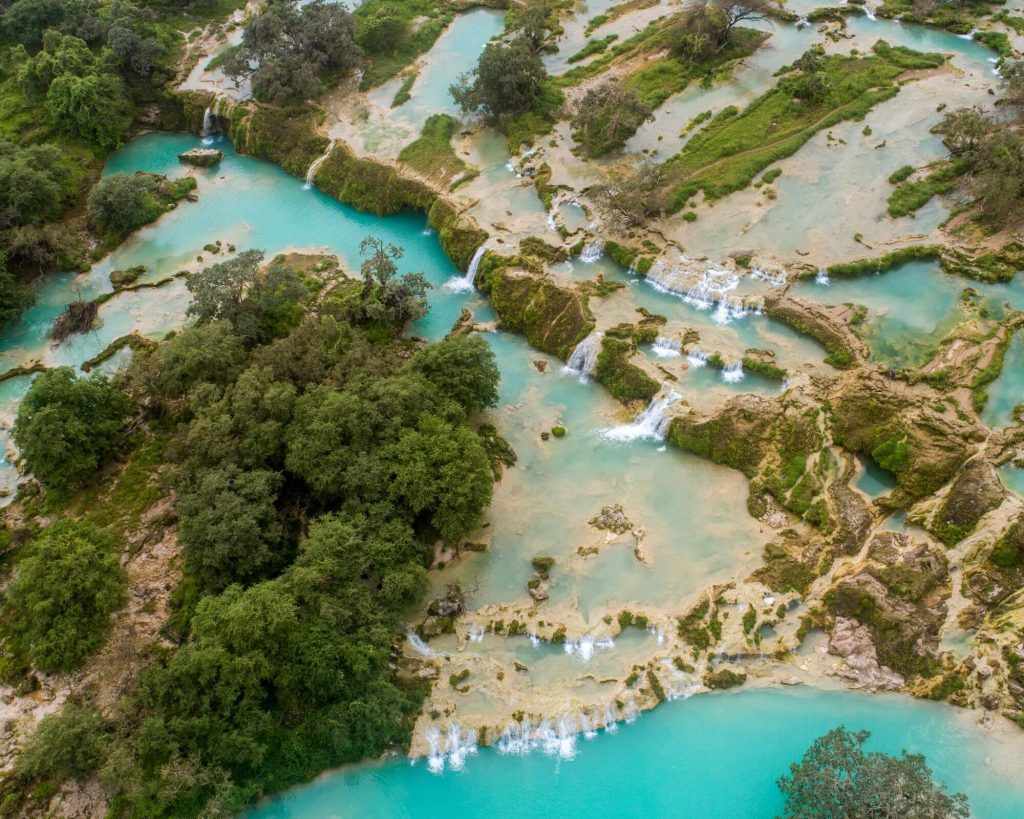 Wodospady i naturalne baseny z błękitną wodą w Wadi Darbat